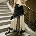 Detailed view of elegant color-block satin skirt with black lace trim and high slit - S / Apricot