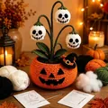 Close-up of Halloween crochet materials including yarn, hooks and finished pot - Skull Pattern