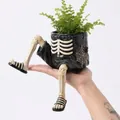 Macro view of unique resin Halloween planter featuring realistic skeleton legs and shorts - Skeleton Legs