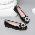 Close-up of black patent leather ballet flats featuring elegant pearl and crystal buckle - 35 / Black