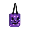 Detail view of purple Halloween candy bucket with glowing LED lights and pumpkin face - Purple