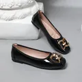 Close-up of black patent leather ballet flats with decorative gold interlocking heart buckle - 35 / Black