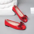 Detailed view of red patent leather ballet flats with large maroon bows and square toes - 35 / Red