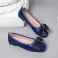 Close-up of blue patent leather ballet flats with a stylish chiffon bow detail - Dark Blue