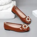 Detailed view of brown patent leather ballet flats with elegant pearl buckles. - 35 / Tan