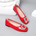 Close-up of red patent leather flats with elegant rhinestone square buckle detail. - 35 / Red