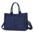 Detailed view of a navy blue canvas tote bag with multi-pockets and a wide wide shoulder strap. - H 25cm W 14cm L 34cm / Dark Blue