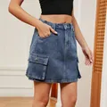 Detail view of blue washed denim cargo skirt with large flap pockets and elastic waist - S / Denim Blue