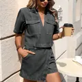 Model wearing a black washed denim two-piece set with V-neck top and irregular skirt - S / Bottoms / Black and Gray
