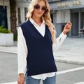 Dettaglio di un elegante gilet in maglia blu scuro con scollo a V sopra una camicia bianca - Nero