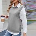 Detail of women's grey knitted vest with side buttons and slit over a white shirt. - S / Tops / Gray