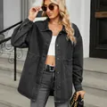 Detailed shot of a women's oversized washed black denim jacket with front pockets - S / Tops / Black and Gray