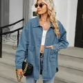 Close-up detail of a light blue washed oversized denim jacket featuring large front pockets - S / Tops / Blue
