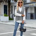 Women's grey cable-knit V-neck sweater vest over a white shirt in street setting - S / Tops / Gray