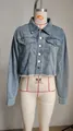 Vista dettagliata della giacca corta in denim con bottoni metallici e orlo a frange - Taglia S / Top / Blu