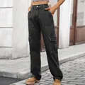 Detailed view of women's dark washed cargo jeans with patch pockets in urban street setting - Black and Gray