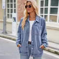 Model wearing a vintage washed light blue denim jacket in an outdoor street setting - S / Tops / Light Blue