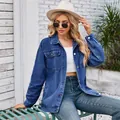 Model wearing a vintage washed blue denim jacket with front pockets in a stylish outdoor setting - S / Tops / Dark Blue