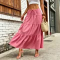 Detail view of a pink tiered maxi skirt with drawstring waist in a street setting - S / Bottoms / Pink