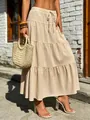 Detail view of a boho beige tiered maxi skirt featuring pleated texture and drawstring waist - S / Bottoms / Khaki