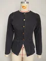 Detailed view of washed black denim jacket featuring elegant gold-tone button closure. - S / Tops / Black and Gray