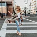 Mujer con un cárdigan largo de punto a rayas con flecos en una calle urbana - S / Tops / Rayas Naranjas