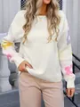 Detailed view of white knitted sweater featuring colorful floral patterns on sleeves. - S / Tops / White