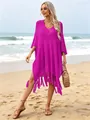 Model wearing a stylish magenta oversized knit beach cover-up with fringe tassels on the sand. - Tops / Rose Red