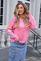 Detailed view of pink oversized knit sweater with colorful flower patterns on sleeves - S / Tops / Pink