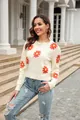 Elegant white crewneck knit sweater with vibrant orange daisy patterns and a soft finish - Apricot