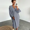 Vista dettagliata di un abito lungo in garza di cotone con scollo a V indossato da modella. - Grigio