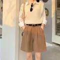 Detail view of brown high-waisted casual shorts with a black belt for summer fashion - S / Bottoms / Tan