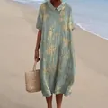 Moderfoto buiten van een groene midi-jurk met bloemen en Peter Pan-kraag op het strand. - S / Jurk (Stijl 27)