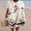 Detail van een witte jurk met poppenkraag en roze kersenbloesemprint op het strand - S / Jurk (Stijl 23)
