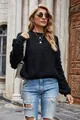 Detail view of a black cropped knitted sweater with textured bubble sleeves on a model. - S / Tops / Black