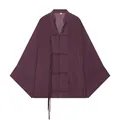 Detailopname van het paarse gedrapeerde shirt met de Chinese knopen en franjes. - Fuchsia
