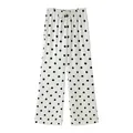 Detailed view of white wide-leg trousers featuring a classic black polka dot pattern - XS / Bottoms / Black Polka Dot