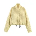 Close-up of yellow jacket with black polka dots featuring high collar and drawstring. - S / Tops / Yellow