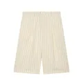 Detailed view of cream pinstriped linen shorts featuring pleats and belt loops. - XS / Bottoms / Striped