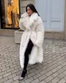 Elegant woman wearing long white faux fur coat on a European street scene. - S / Tops / White