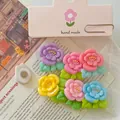 Detalle macro de coloridas flores de resina DIY en bolsas de embalaje rosa. - Juego de Flores de Durazno Magnéticas (Con Tarjeta) / Juego de 6
