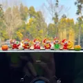 Six cute cartoon God of Wealth figurines displayed on a car dashboard for good luck. - 8-Piece Fortune Set (6 Caishen and 2 Oranges)