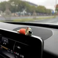 Close-up of a mini healing dog figurine ornament on a car dashboard display screen - Photography Cat