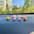 Detailed view of two cute Maneki-neko lucky cat figurines with oranges on a car dashboard - 2 Cats Plus 2 Peeling Tangerines Set