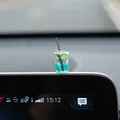 Detailed view of a miniature blue soda drink car ornament placed on a vehicle screen - Lime Tea