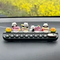 Close-up view of a creative panda temporary parking phone plate for car interiors - 4 Standing Blessing Pandas / Black