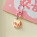 Macro detail of a cute peach toast bread keychain charm featuring a pink lobster clasp - Strawberry Cookie