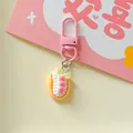 Detailed view of a cute pink dessert food play keychain with realistic cream and strawberry - Strawberry Cream