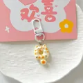 Close-up of a cute donut-shaped cat keychain with orange spots and white lobster clasp - Yellow Spotted Cat