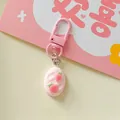 Detail shot of a pink keychain with textured oval charm and realistic 3D strawberry accents. - Oval Bread